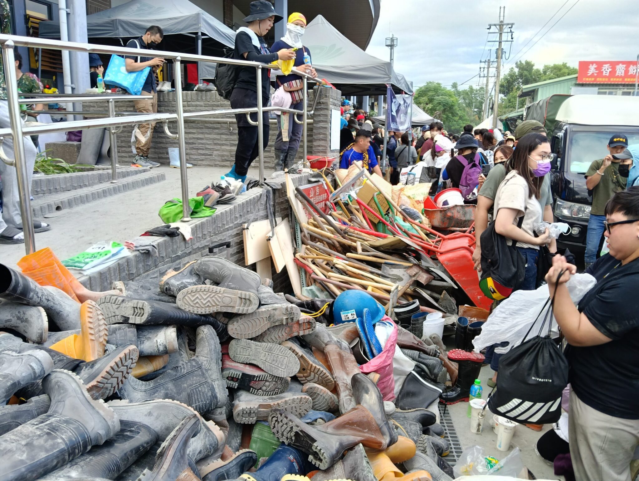 花蓮光復車站前堆滿志工的雨鞋及鏟子工具。