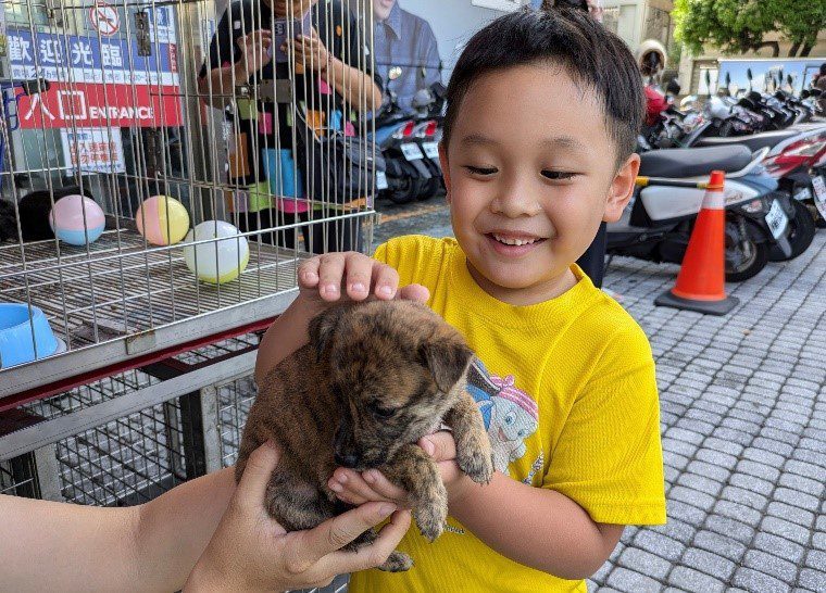 小朋友與狗狗第一次互動接觸。動保處提供